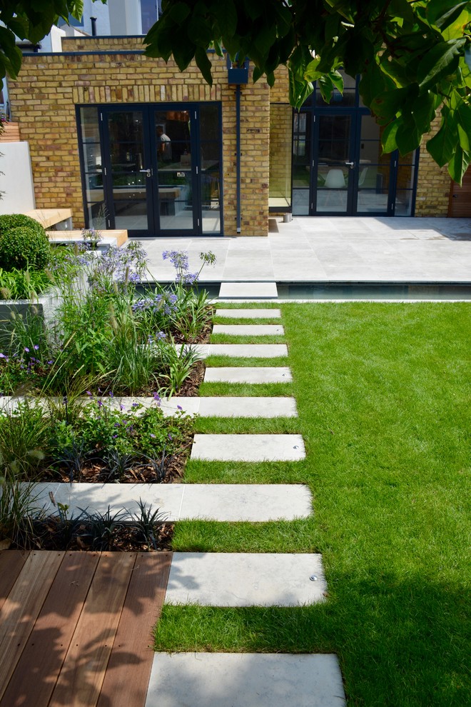 Ispirazione per un laghetto da giardino design esposto in pieno sole di medie dimensioni e dietro casa in estate con pavimentazioni in pietra naturale