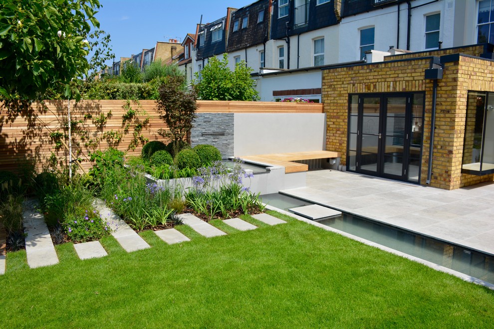 Esempio di un laghetto da giardino design esposto in pieno sole di medie dimensioni e dietro casa in estate con pavimentazioni in pietra naturale
