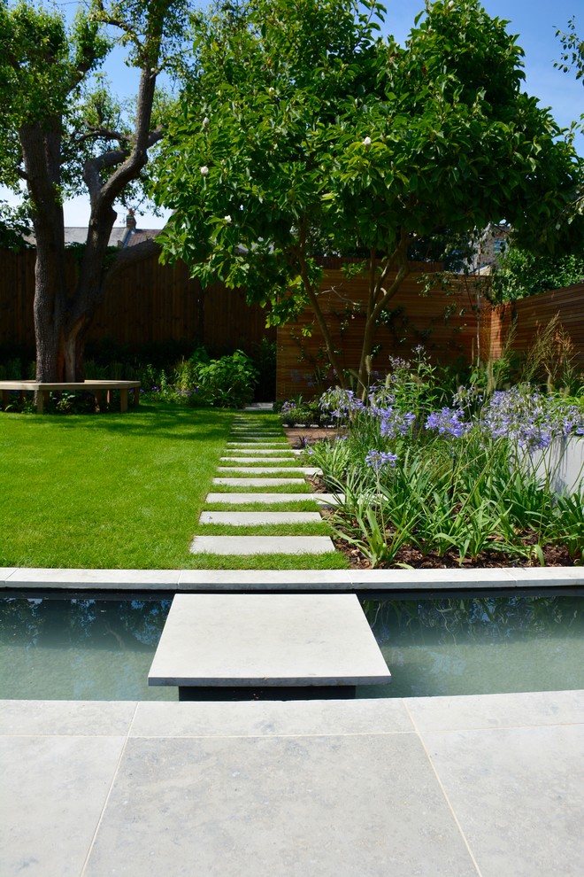 Diseño de jardín contemporáneo de tamaño medio en verano en patio trasero con estanque, exposición total al sol y adoquines de piedra natural