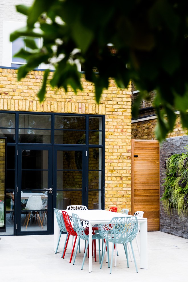 Mittelgroßer Moderner Gartenteich im Sommer, hinter dem Haus mit direkter Sonneneinstrahlung und Natursteinplatten in London