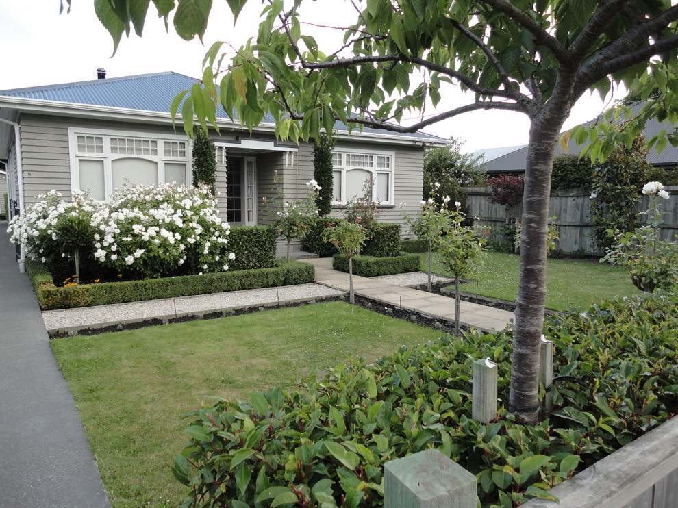 На фото: регулярный сад на переднем дворе в стиле кантри с садовой дорожкой или калиткой