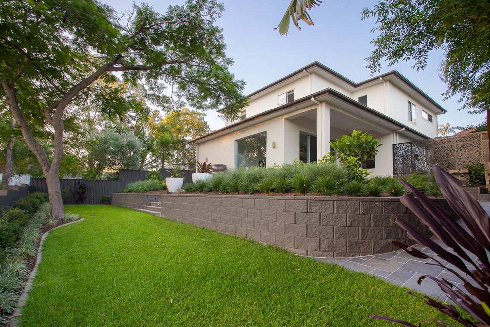 Photo of a mid-sized modern backyard stone formal garden in Brisbane.