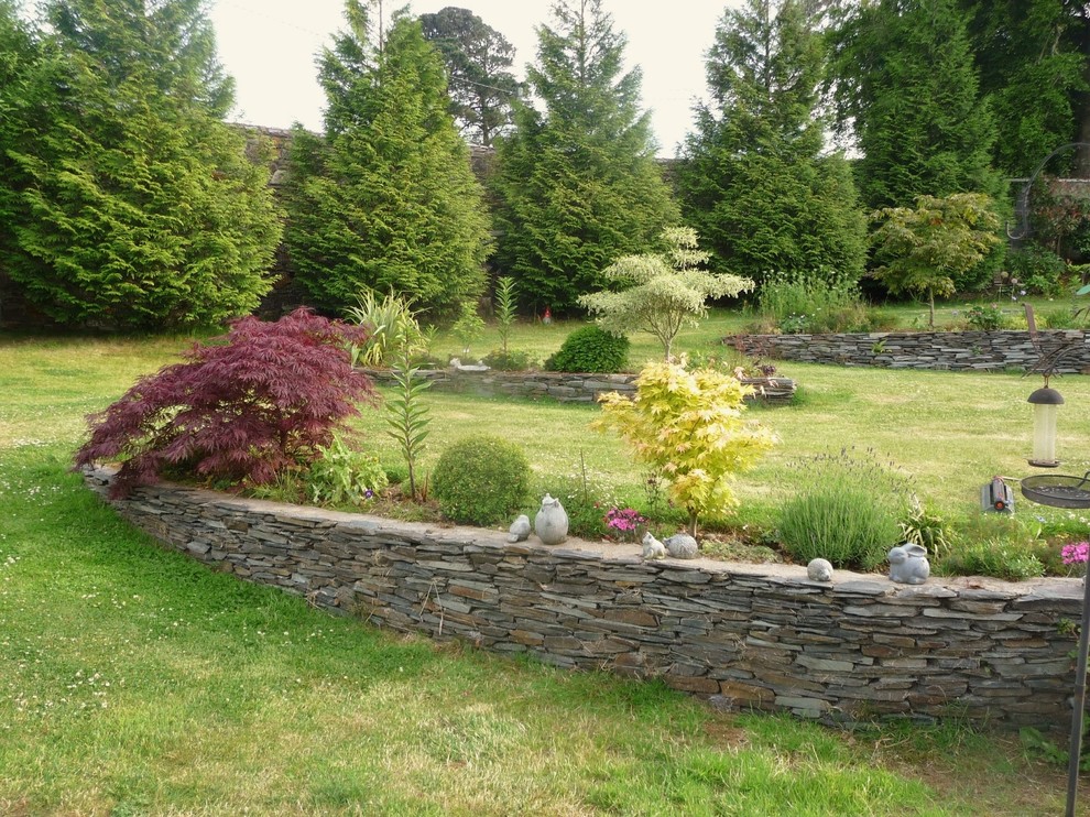 Esempio di un ampio giardino country esposto in pieno sole con un pendio, una collina o una riva