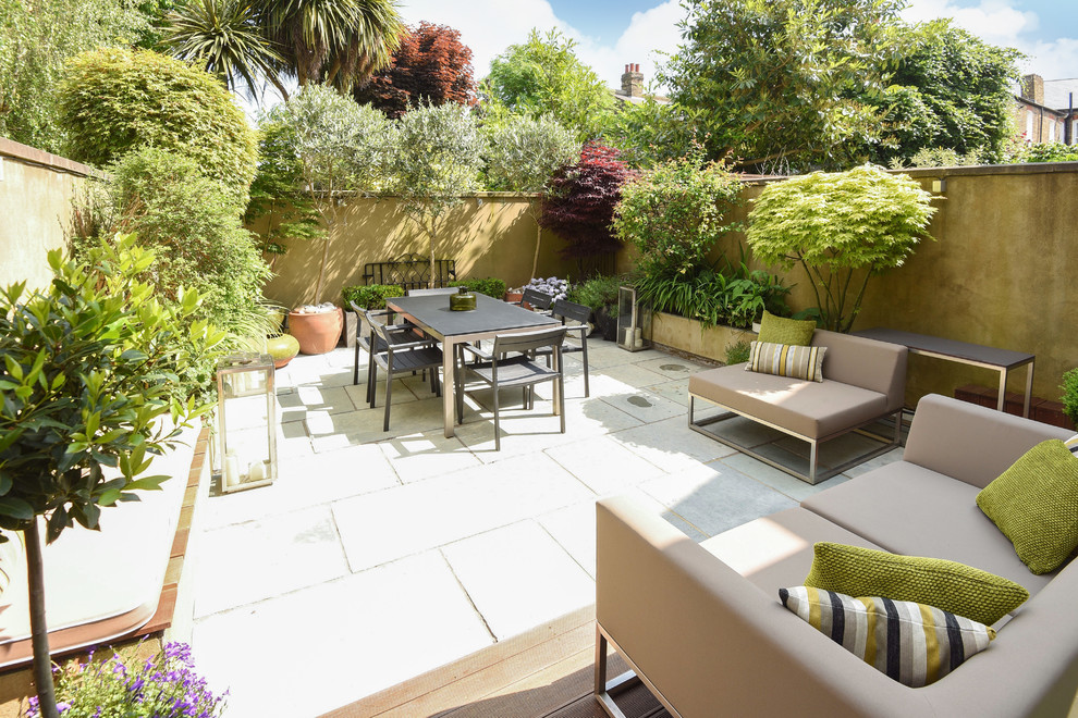 Photo of a medium sized contemporary back garden in London with natural stone paving.