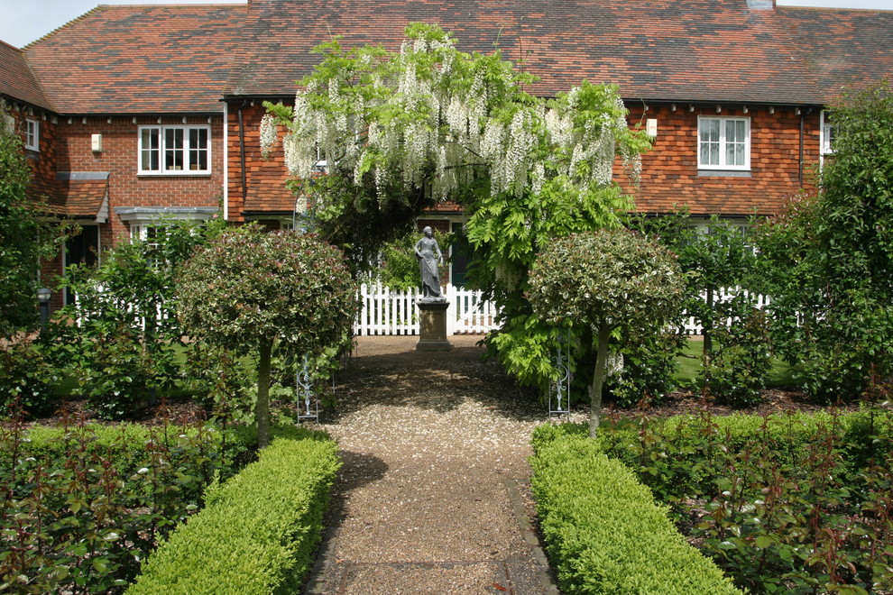 Immagine di un giardino formale classico dietro casa con ghiaia
