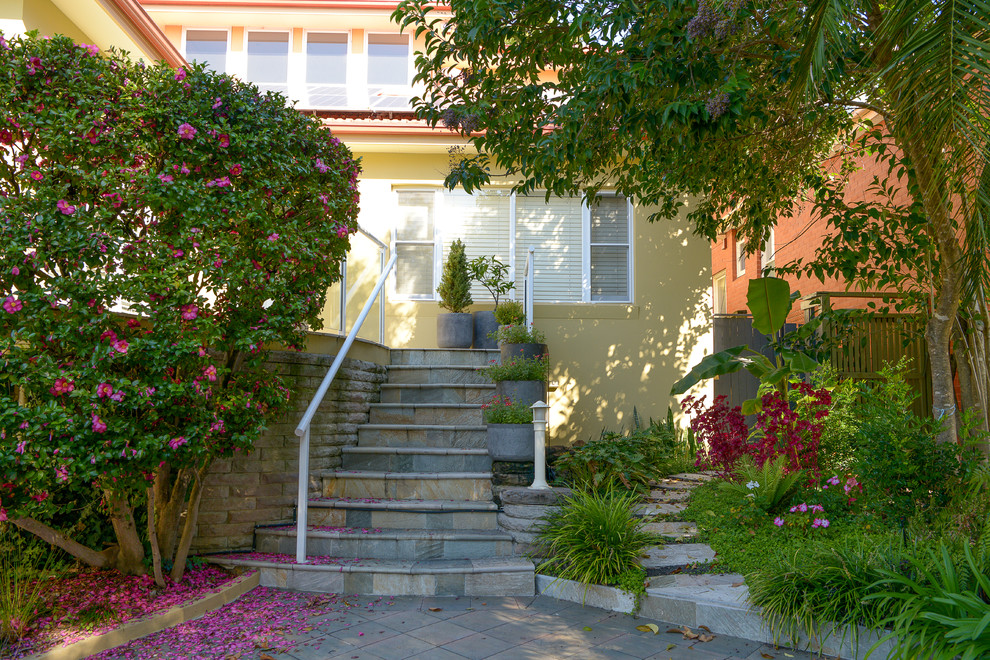 На фото: участок и сад среднего размера на переднем дворе в классическом стиле с полуденной тенью и мощением тротуарной плиткой