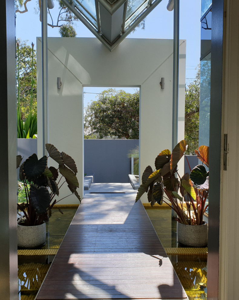 Immagine di un giardino tropicale esposto in pieno sole dietro casa con pavimentazioni in pietra naturale