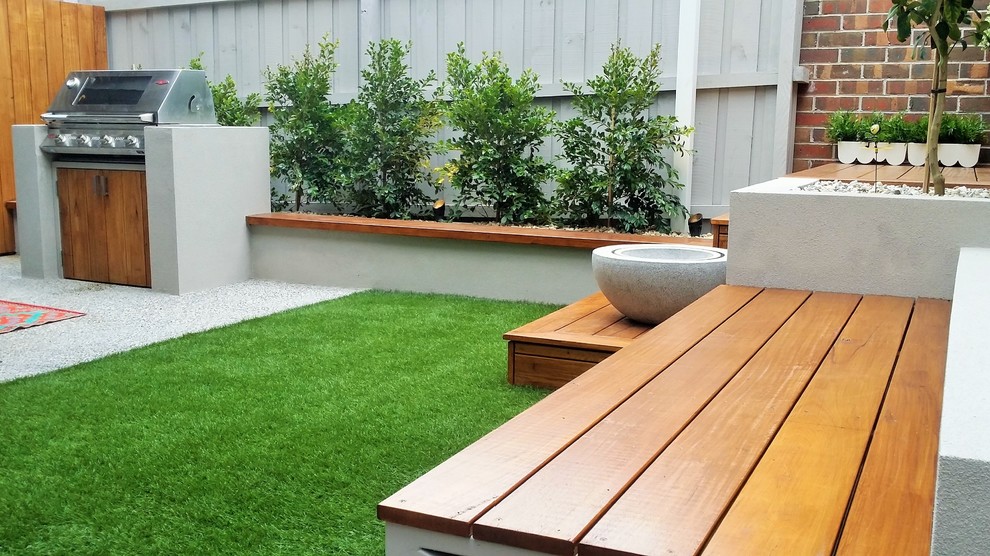 Small contemporary back partial sun garden in Melbourne with a water feature and decking.