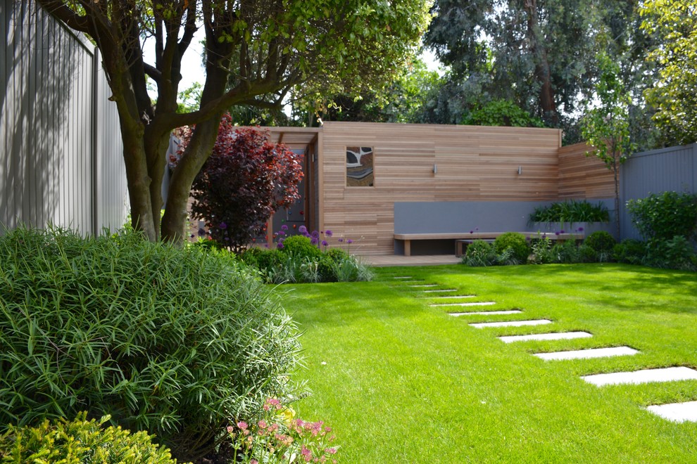 Exemple d'un jardin arrière tendance de taille moyenne avec une exposition ensoleillée et une terrasse en bois.