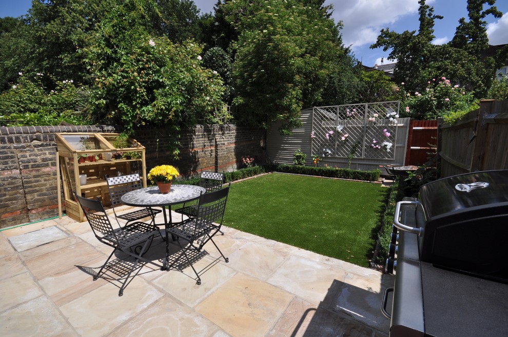 Cette image montre un jardin arrière design avec une exposition ensoleillée et des pavés en pierre naturelle.