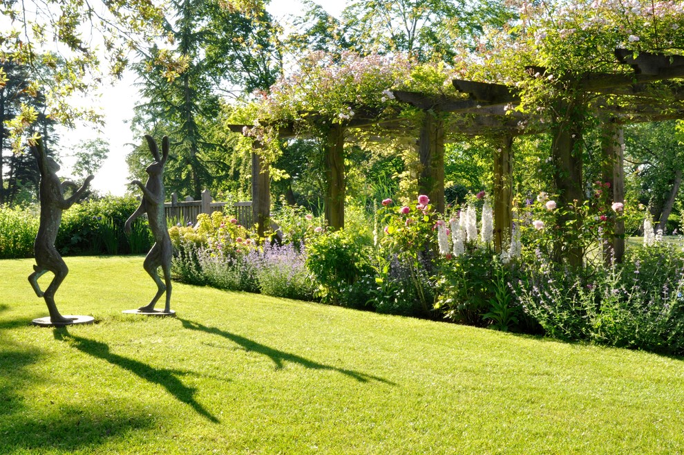 Свежая идея для дизайна: большой солнечный, летний регулярный сад на заднем дворе в стиле кантри с садовой дорожкой или калиткой, хорошей освещенностью и покрытием из каменной брусчатки - отличное фото интерьера