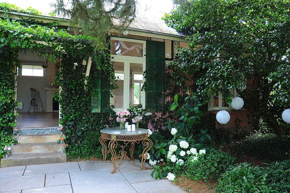 Immagine di un giardino chic davanti casa in estate con pavimentazioni in pietra naturale e scale