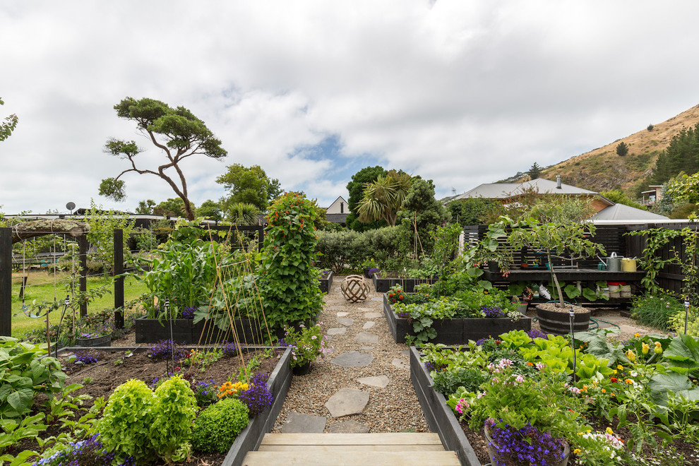 Photo of a traditional formal garden in Christchurch with a potted garden and natural stone paving.