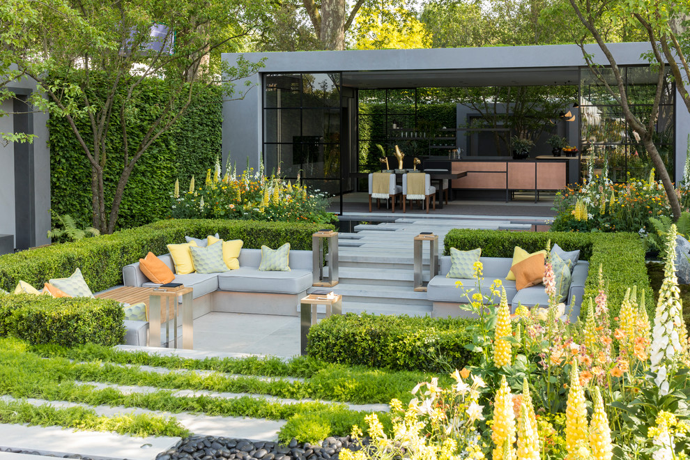 Photo of a large contemporary formal garden seating in London with natural stone paving.