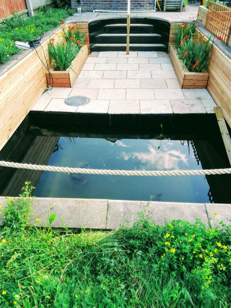 Inspiration pour un grand jardin arrière design avec un bassin, une exposition ensoleillée et des pavés en pierre naturelle.