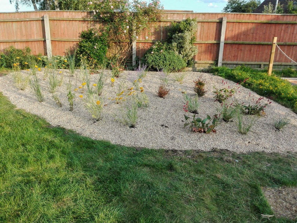 Inspiration för en stor funkis trädgård i full sol på sommaren, med en damm och grus