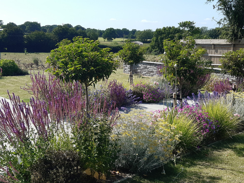 Esempio di un grande giardino formale country esposto in pieno sole dietro casa in estate con un ingresso o sentiero e pavimentazioni in pietra naturale