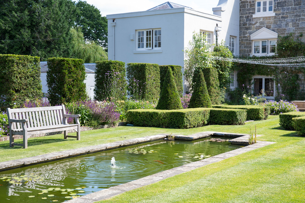 Imagen de jardín tradicional en patio trasero con estanque y jardín francés