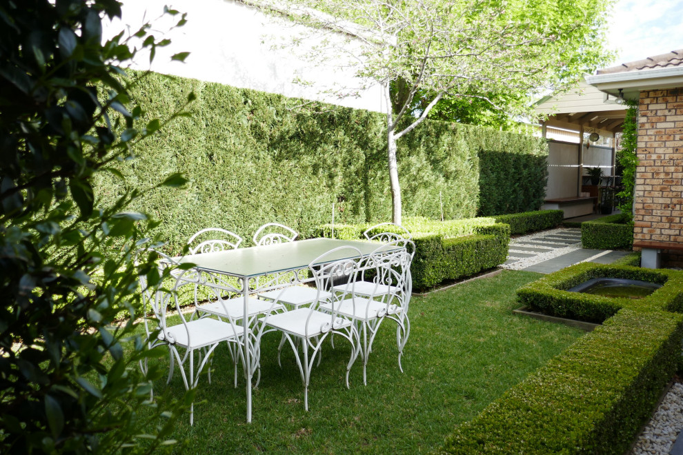 Ejemplo de jardín de estilo de casa de campo pequeño en primavera en patio con jardín francés, exposición total al sol, adoquines de piedra natural y privacidad