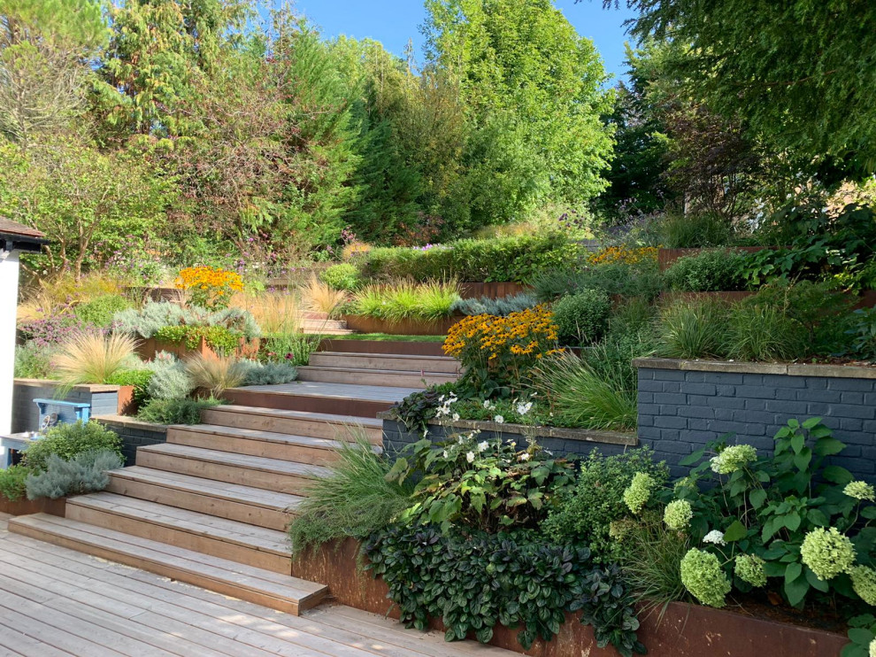 This is an example of a contemporary garden in Other with a retaining wall and decking.