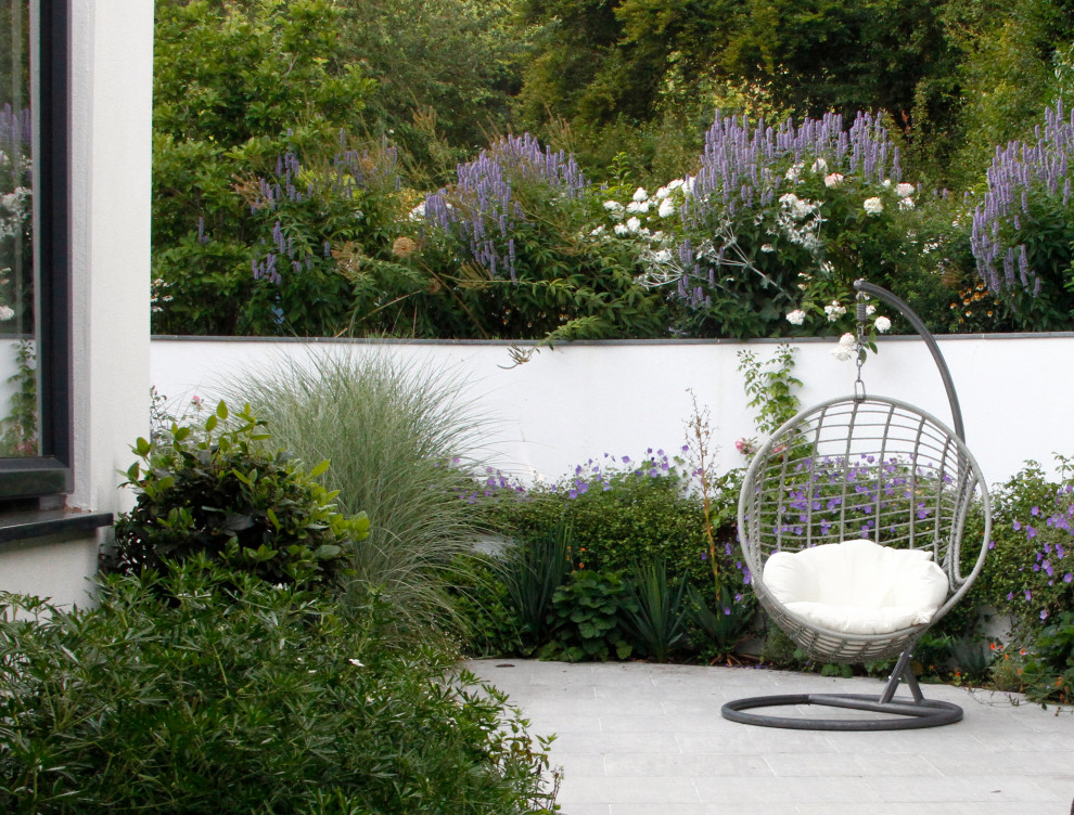 Пример оригинального дизайна: летний регулярный сад среднего размера на внутреннем дворе в стиле модернизм с водопадом, полуденной тенью и покрытием из каменной брусчатки