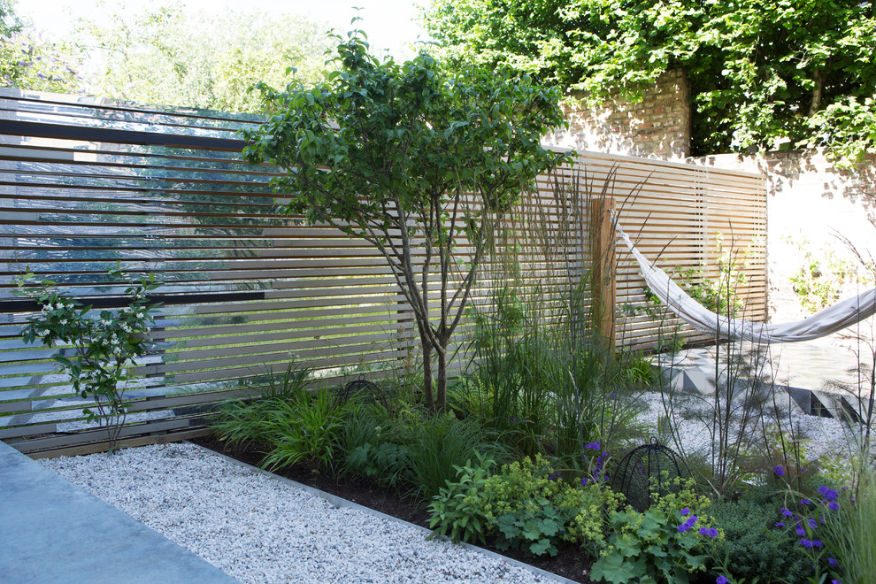 Idee per un piccolo giardino contemporaneo esposto in pieno sole dietro casa in primavera con ghiaia