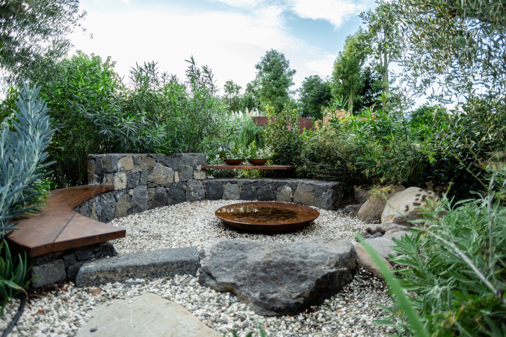 Diseño de jardín de secano mediterráneo pequeño en verano con fuente, exposición total al sol y gravilla