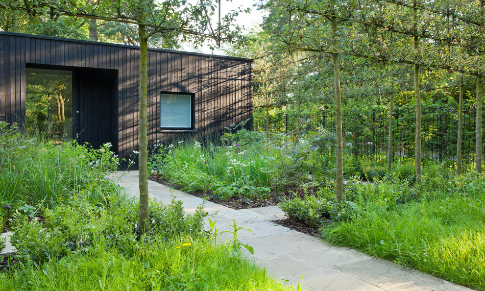 Immagine di un giardino country esposto a mezz'ombra dietro casa con pavimentazioni in pietra naturale
