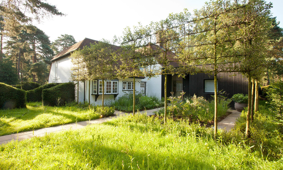 Foto de camino de jardín de estilo de casa de campo en patio delantero con jardín francés, exposición parcial al sol y adoquines de piedra natural