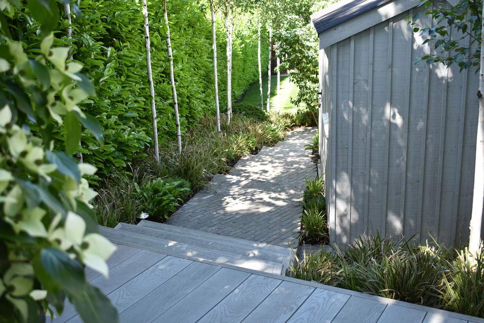 Cette image montre un jardin surélevé arrière minimaliste avec une terrasse en bois.
