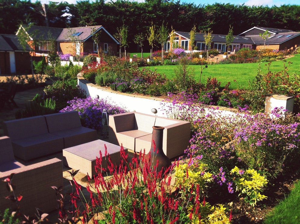 Großer Country Garten hinter dem Haus mit direkter Sonneneinstrahlung und Natursteinplatten in Surrey