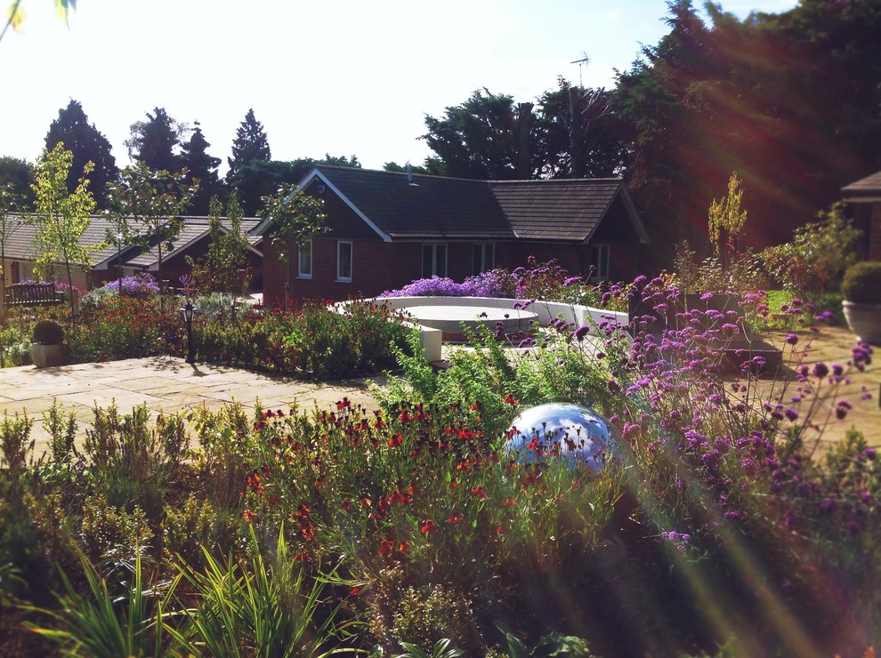 Großer Landhaus Garten hinter dem Haus mit direkter Sonneneinstrahlung und Natursteinplatten in Surrey