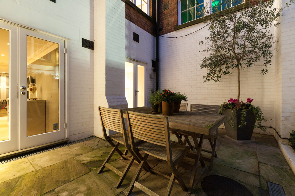 Inspiration for a medium sized contemporary courtyard garden in London with natural stone paving.