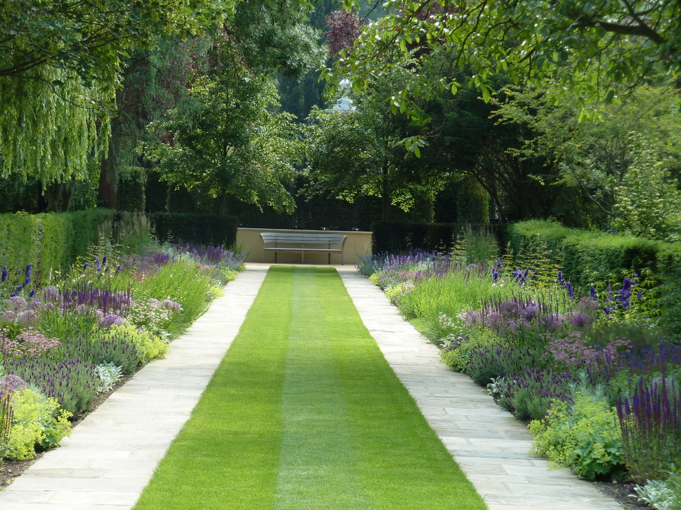 Inspiration för klassiska trädgårdar, med en trädgårdsgång och naturstensplattor