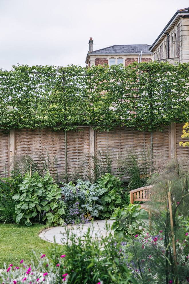 Imagen de jardín tradicional pequeño en verano en patio delantero con jardín francés, huerto, exposición total al sol y adoquines de piedra natural
