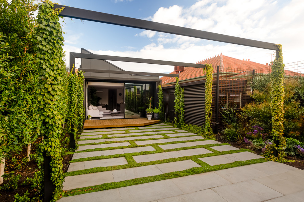 Imagen de jardín minimalista de tamaño medio en primavera en patio trasero con jardín francés, privacidad, exposición total al sol y adoquines de piedra natural