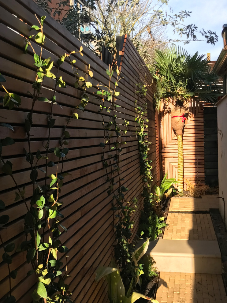 Immagine di un piccolo privacy in giardino contemporaneo esposto a mezz'ombra dietro casa in estate con pavimentazioni in pietra naturale
