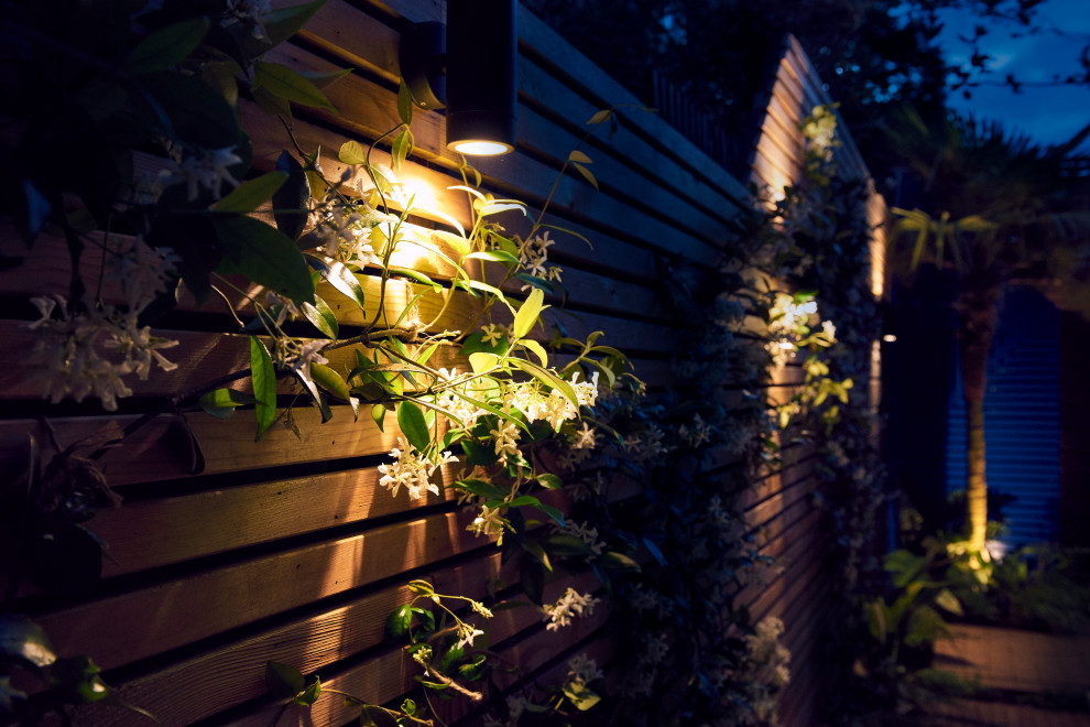 На фото: маленький летний участок и сад на заднем дворе в морском стиле с полуденной тенью, покрытием из каменной брусчатки и с деревянным забором для на участке и в саду