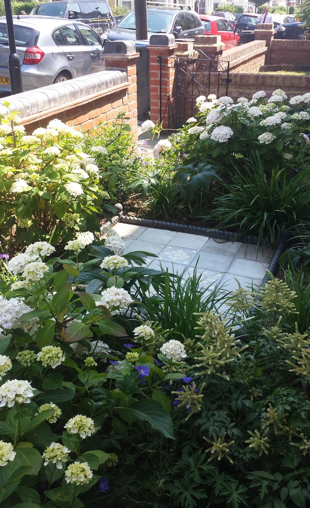 Idee per un piccolo giardino formale tradizionale in ombra davanti casa in estate con un ingresso o sentiero e pavimentazioni in cemento