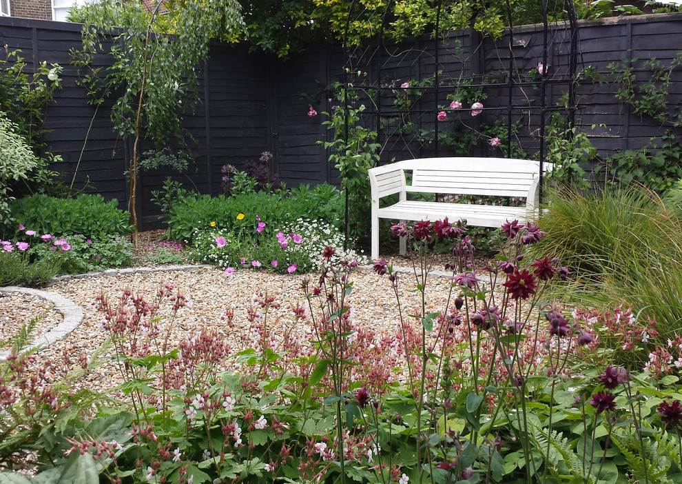 На фото: маленький летний регулярный сад на внутреннем дворе в классическом стиле с садовой дорожкой или калиткой, полуденной тенью и покрытием из гравия для на участке и в саду с