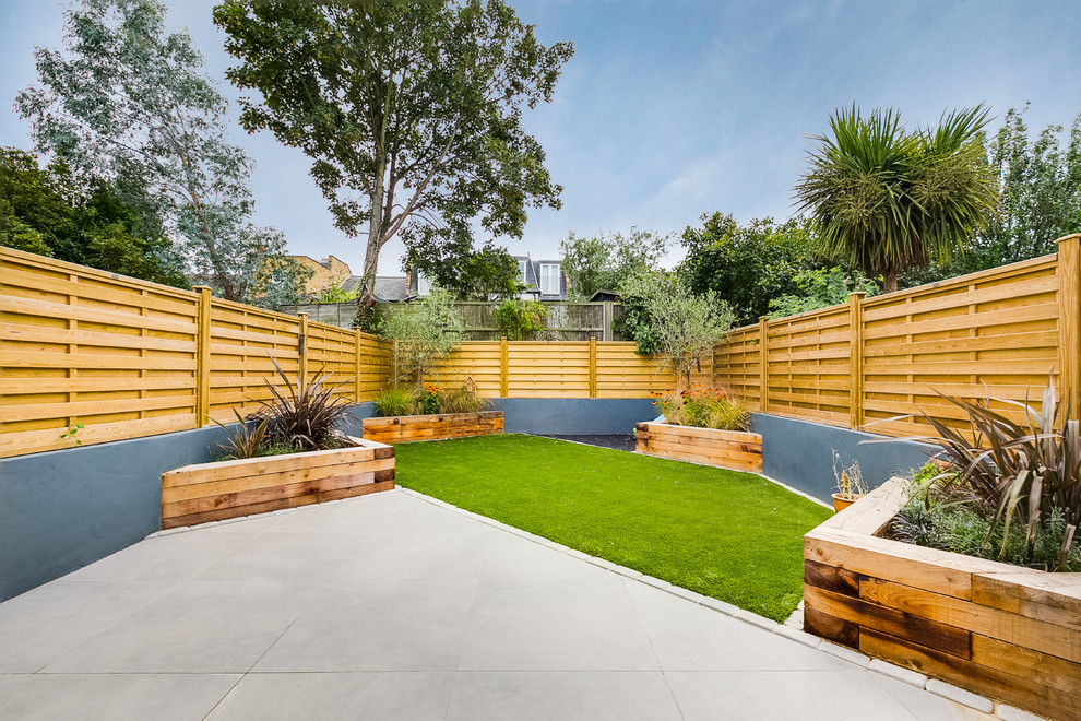 Design ideas for a contemporary back full sun garden in London with a potted garden and concrete paving.