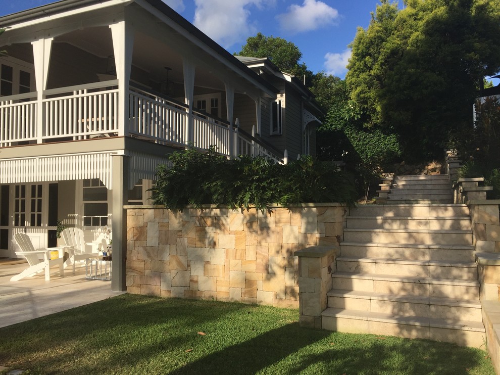 Inspiration for a medium sized world-inspired side formal partial sun garden in Brisbane with a retaining wall and natural stone paving.