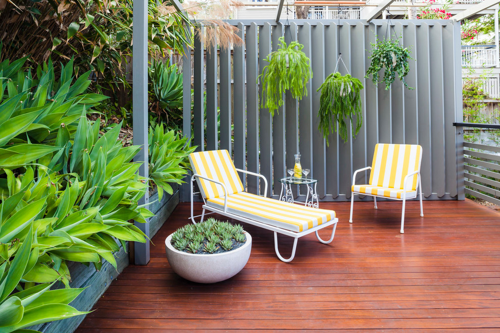 This is an example of a retro back partial sun garden for summer in Brisbane with decking.