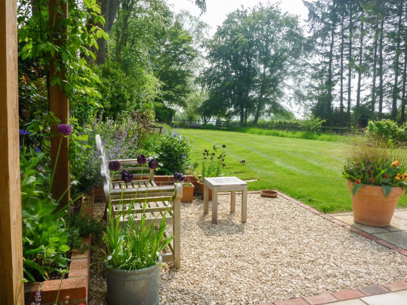 Photo of a medium sized traditional back garden for summer in Hampshire with gravel.