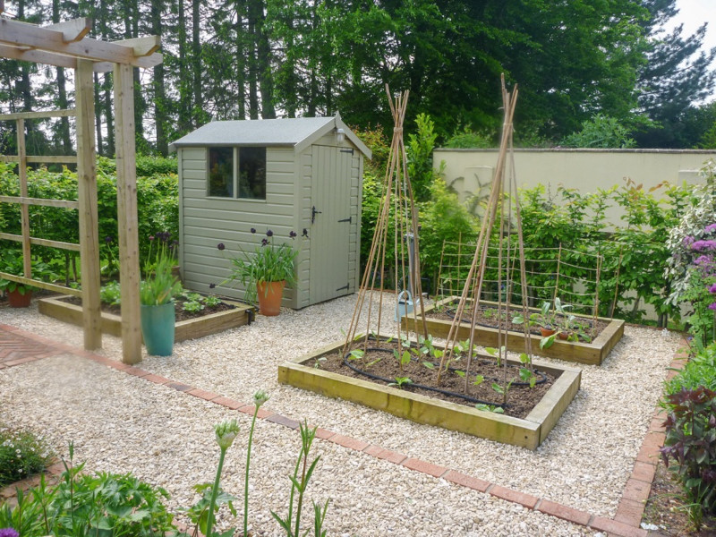 Design ideas for a medium sized classic back garden for summer in Hampshire with gravel.