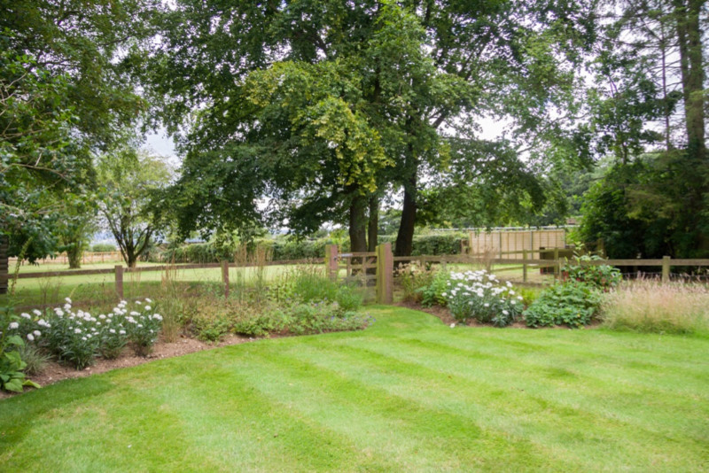 Design ideas for a medium sized classic back garden for summer in Hampshire.