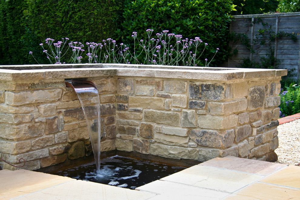 Contemporary back full sun garden in Hampshire with a water feature.