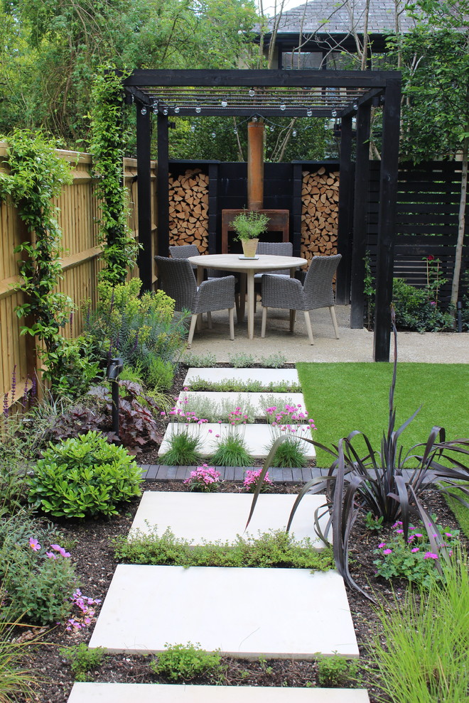 Geometrischer, Kleiner, Halbschattiger Moderner Garten im Sommer, hinter dem Haus mit Dielen und Pergola in Hampshire