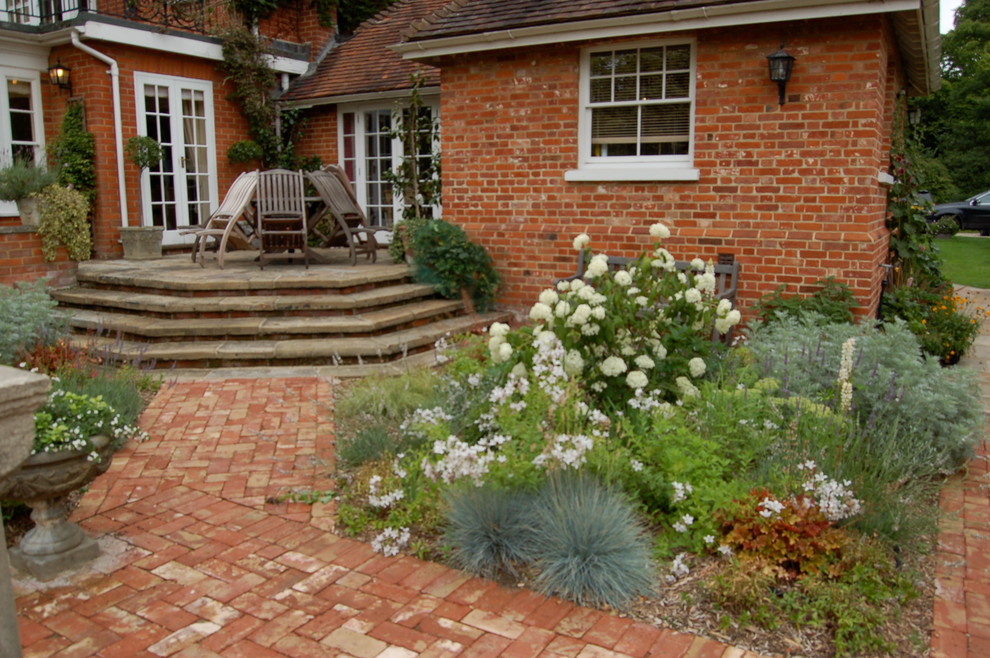 Идея дизайна: большой регулярный сад на заднем дворе в классическом стиле с мощением клинкерной брусчаткой