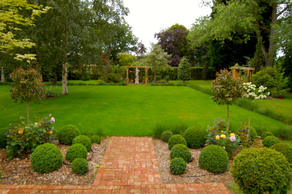 Foto de jardín tradicional grande en patio trasero con jardín francés y adoquines de ladrillo